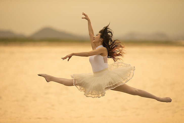 woman in white sleeveless dress doing ballet