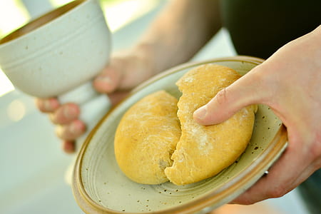 person holding saucer with baked bread
