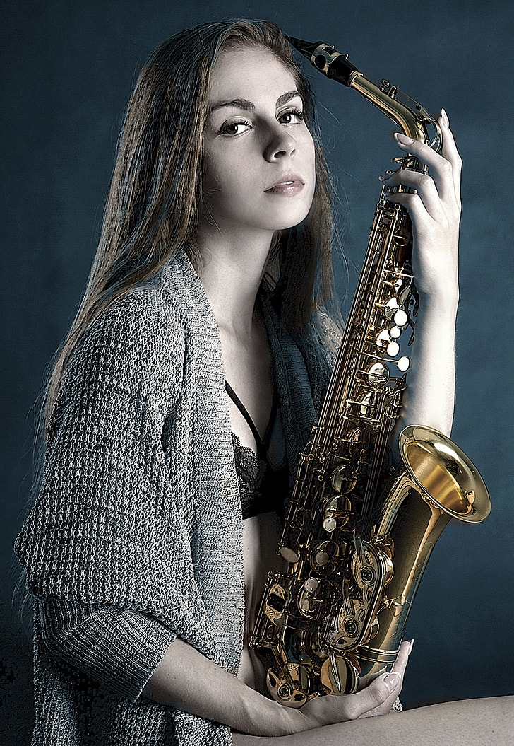 woman holding brass saxophone photography
