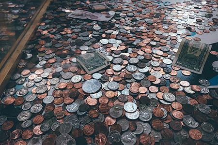 coins and banknotes on black surface