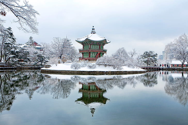 green and red pagoda covered of snow during daytime