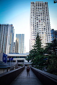 man standing on stairs taking photo with high-rise building background