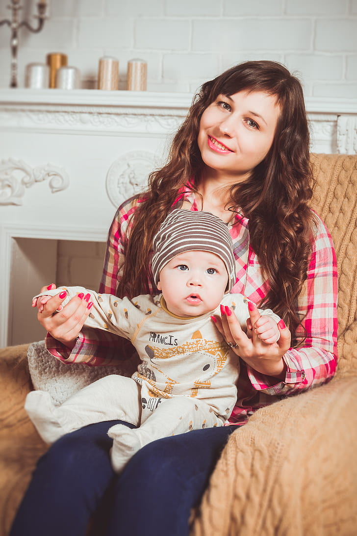 woman in red and brown plaid dress shirt holding baby