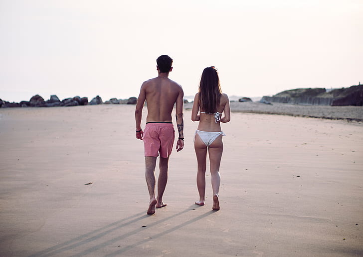 women's white bikini and men's red beach short