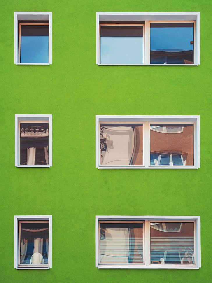 green concrete building with white frame window