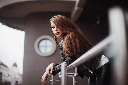 woman in black leather jacket staring at terrace