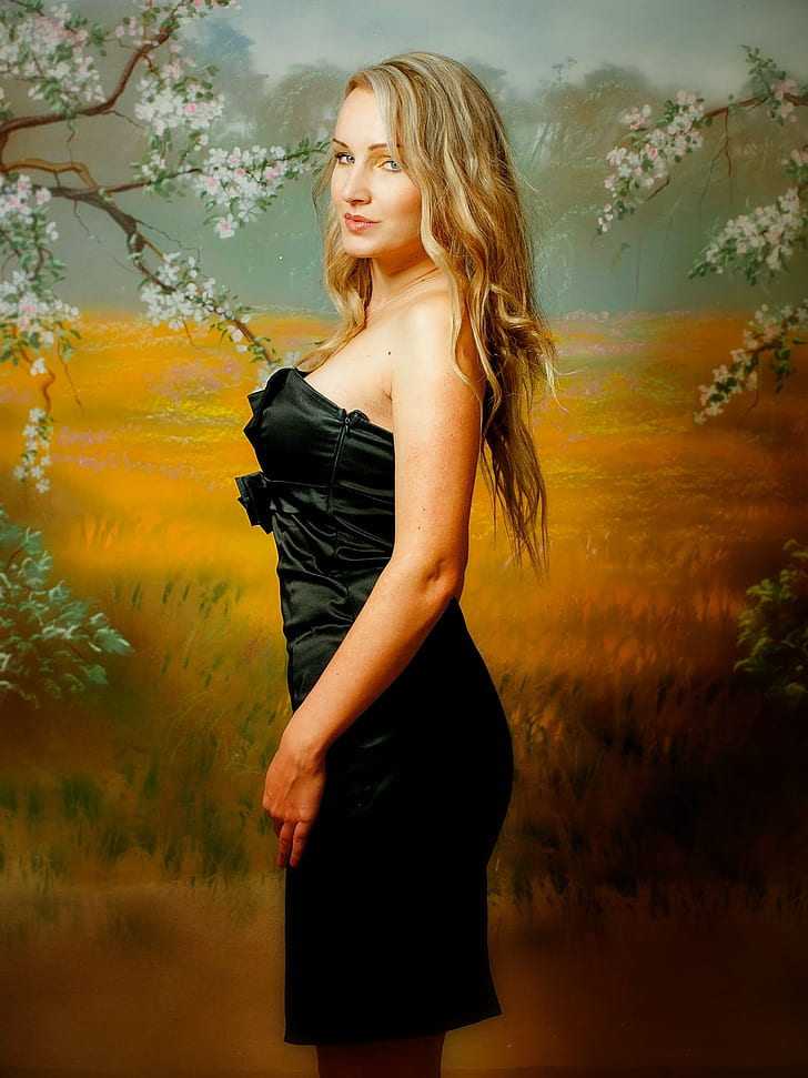 blonde haired woman in black dress standing beside wheat field painting