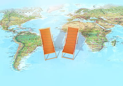 photo of two brown wooden lounge chairs on world map