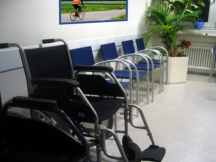 black and gray wheelchair beside blue chair with gray steel frame