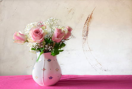 pink-and-yellow roses in white ceramic vase
