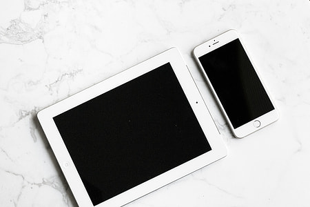 white iPad beside silver iPhone  6