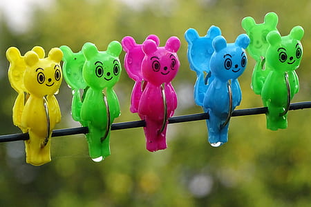 closed photography of five assorted-color bear clothes clips on cable
