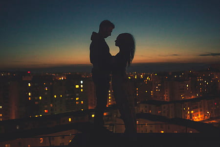 man and woman standing at top of building's edge photo