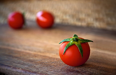 red tomato fruit on brown surface
