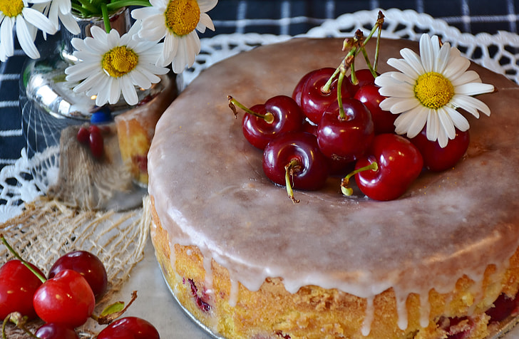round baked cake with cherries