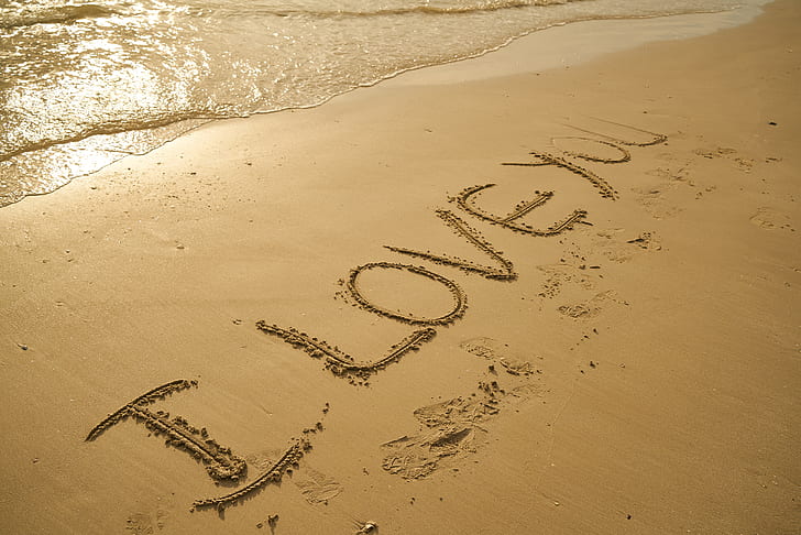 brown sand with I LOVE YOU text during daytime