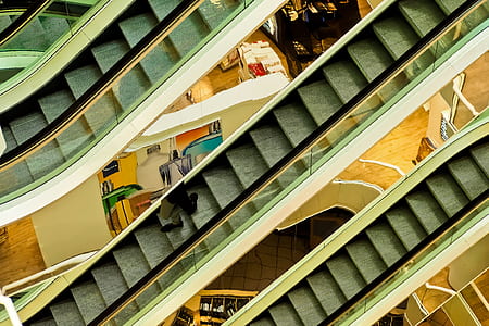 person on gray escalator at inside building