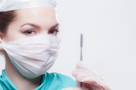 woman wearing face mask and holding scalpel knife