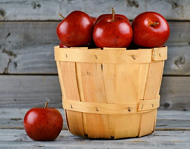 bunch of red apples in brown wooden bucket