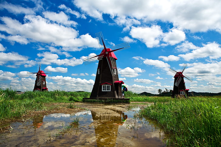 three brown-and-red windmills photo during daytime