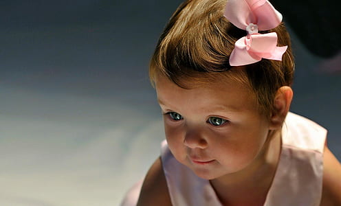 toddler girl wearing white sleeveless top with pink bow