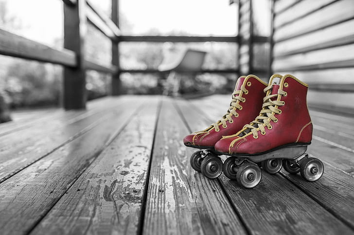 selective color photography of pair of red roller skates