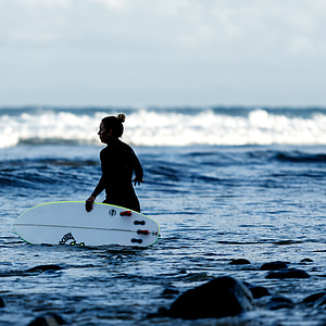 woman carrying surfboard