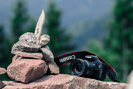 DSLR camera resting on rocks in outdoor setting