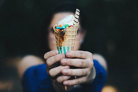 person holding vanilla ice cream with cone