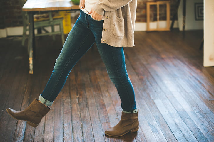 person wearing blue jeans and pair of brown leather booties