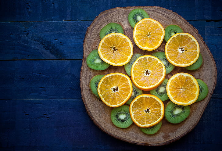 citrus fruit and kiwi on brown slab