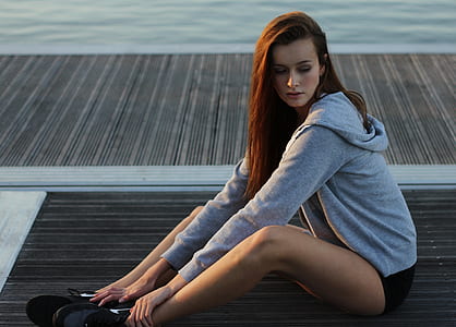 photo of woman sitting on dock