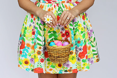 Woman in dress holding basket of Easter Eggs