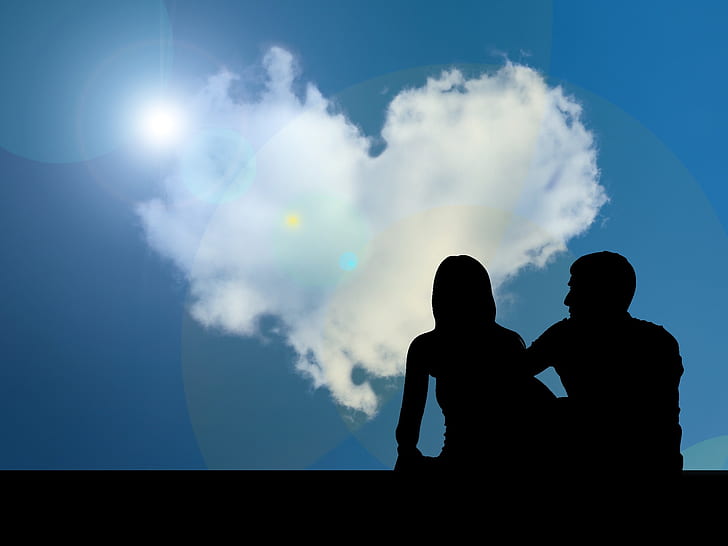 silhouette of man and woman facing heart-shaped cloud