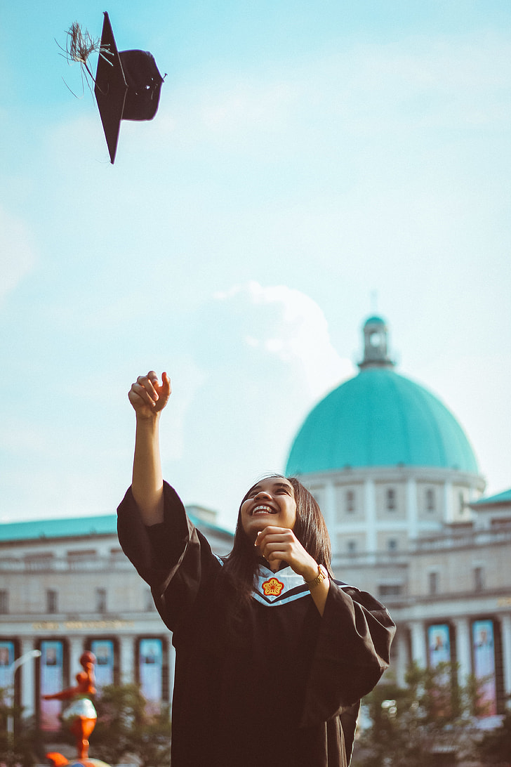 woman tossing her graduation hat