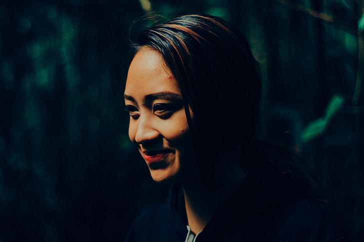 Portrait shot of an Asian woman’s face with smile in forest