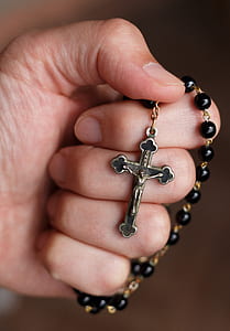 person holding black rosary