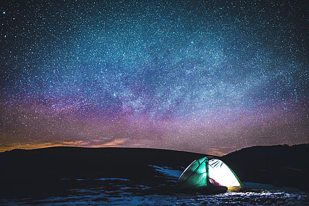 Camping in tent under the stars in the night sky