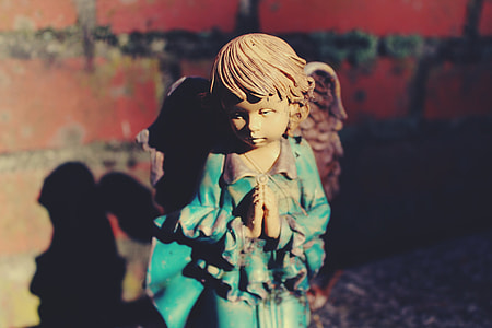 photography of brown-haired angel ceramic figurine