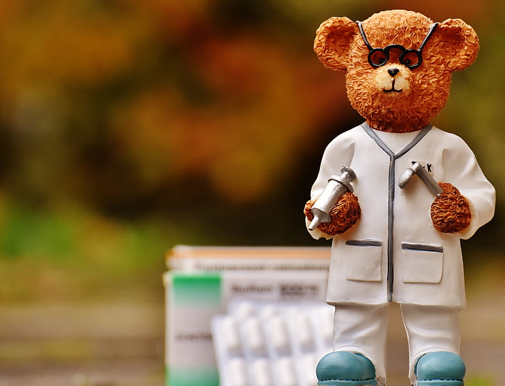 focus photo of doctor bear figurine