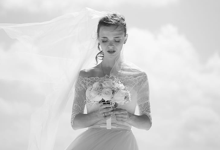 grayscale photo of woman wearing wedding gown holding bouquet