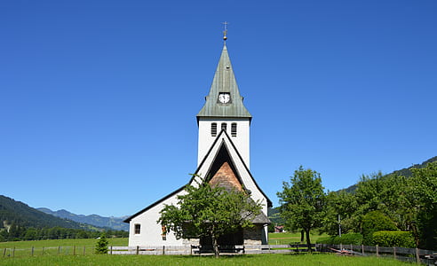 White and Grey Church Near Trees Under Clear Blue Sky during Daylight