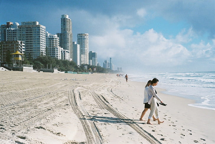 two women walking towards the beach