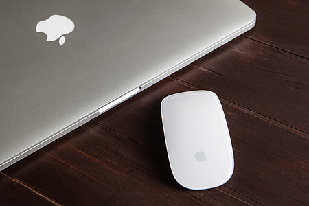 Close-up shot of a Macbook Pro and Magic Mouse on a wooden desk, image captured with a Canon 5D DSLR