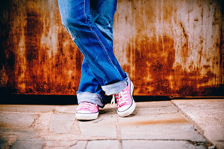 person wearing blue jeans and pink Converse low-top sneakers