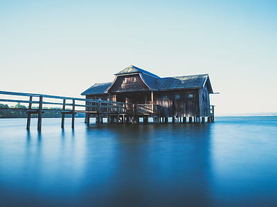 Brown Wooden House on Body of Water With Dock