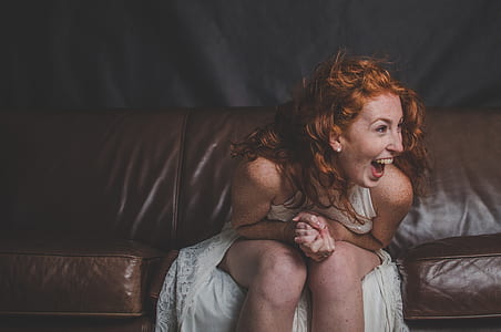 woman wearing white dress sitting on leather couch