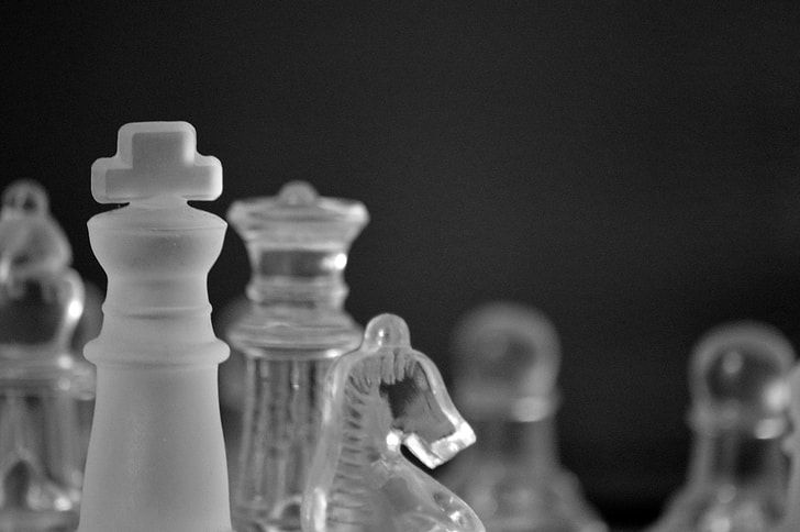 clear glass horse chess piece beside king