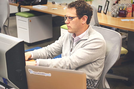 man in gray half-zip jacket work with computer