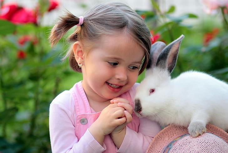 photo of girl in pink top beside white rabbit